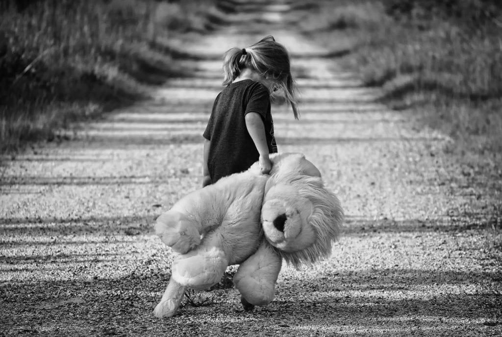 Child walking with stuffed animal