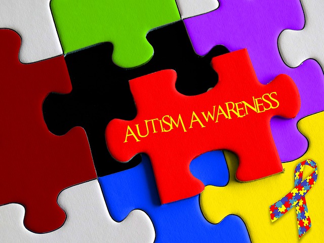 A close up of brightly colored puzzle pieces, with one of hem labelled "Autism"